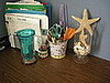 I'm currently using a sandpail for my pens, scissors and other stuff. The vase holds shells from vacations.
